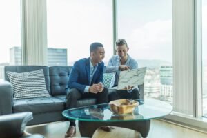 Follow Up Boss vs Lofty: a real estate agent reviewing listings with a client on a laptop