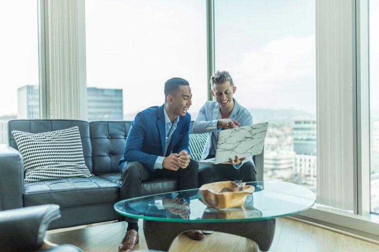 Follow Up Boss vs Lofty: a real estate agent reviewing listings with a client on a laptop