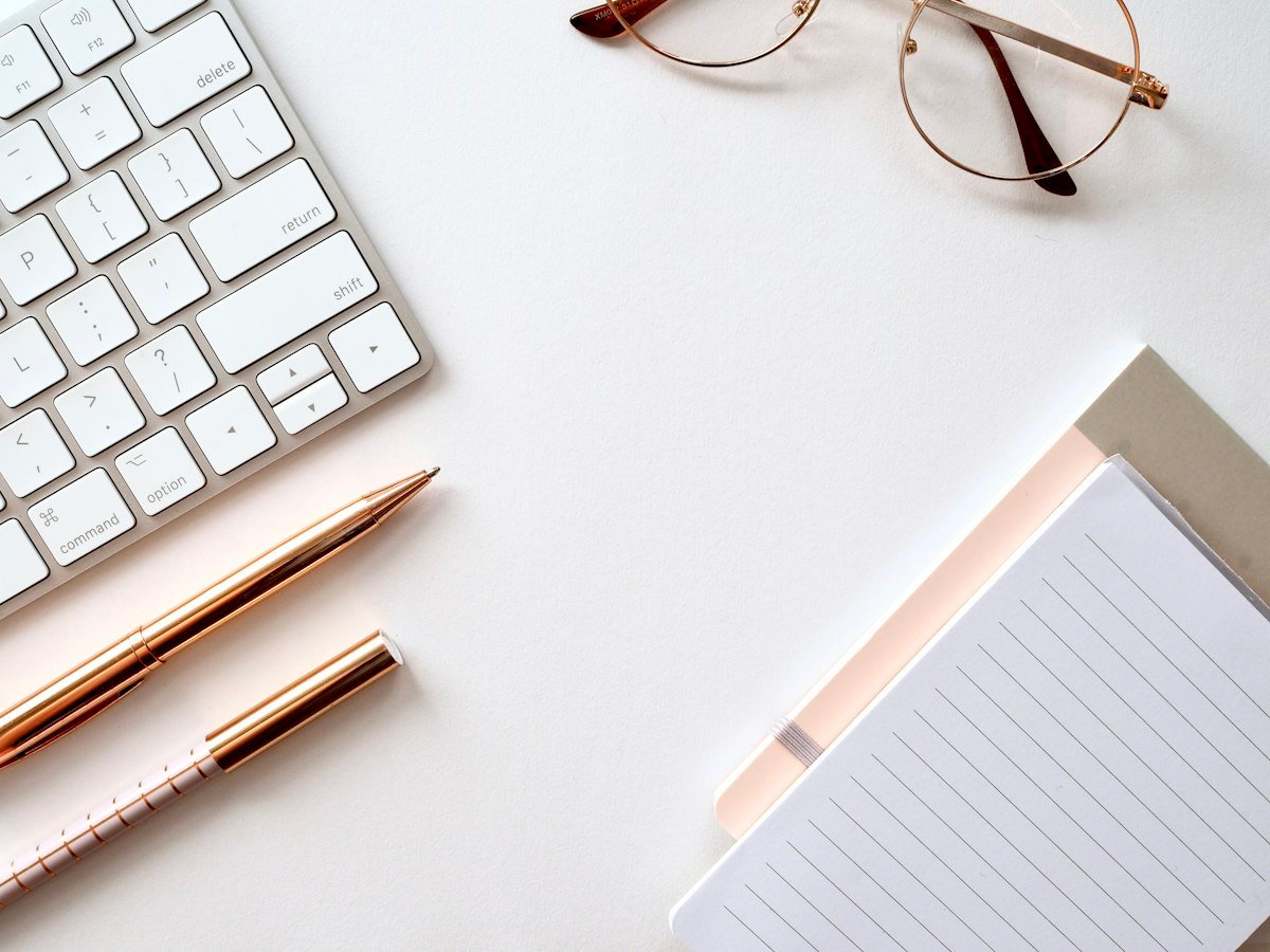 Proposal template workflow: a tidy desk with keyboard, notebook and pens for drafting and sending proposals